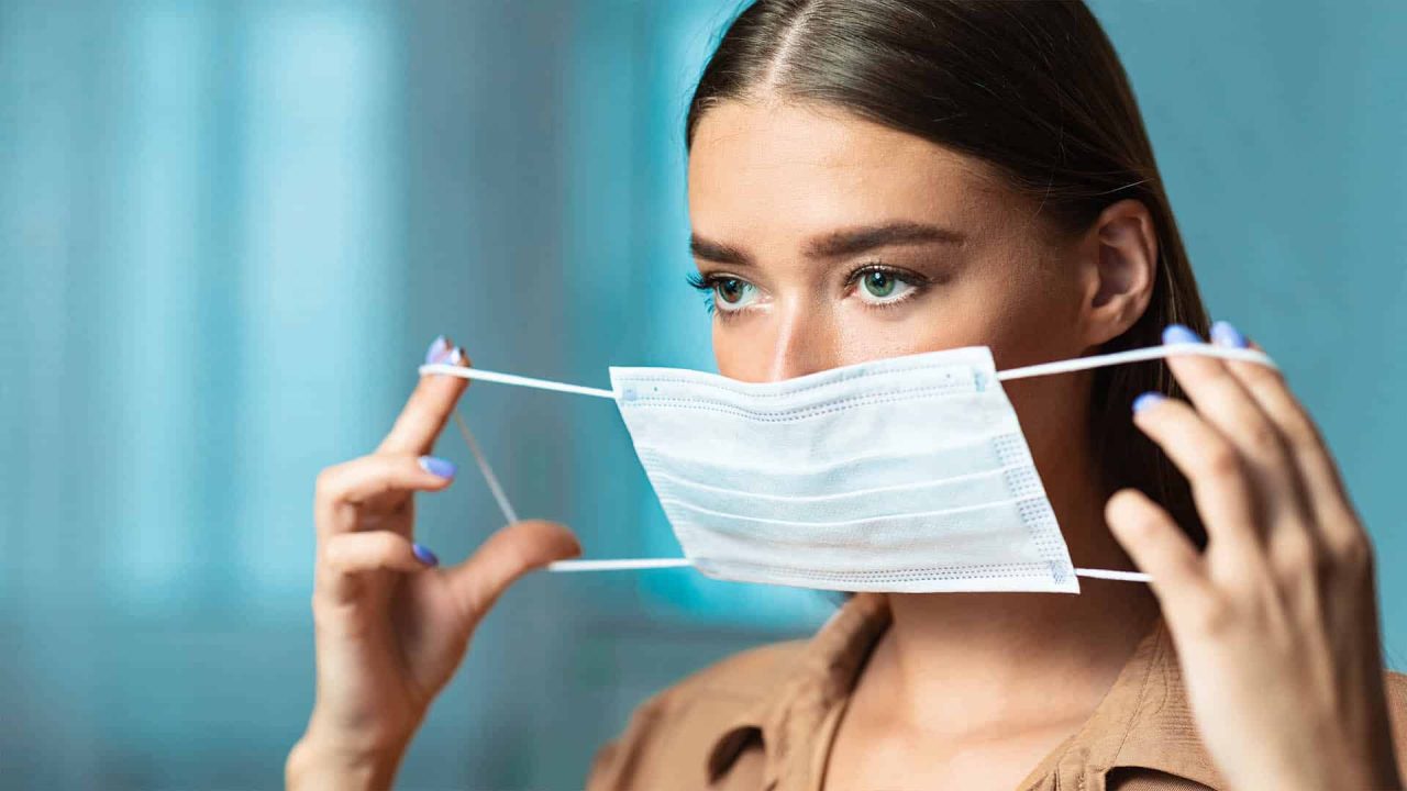 a woman putting on a mask
