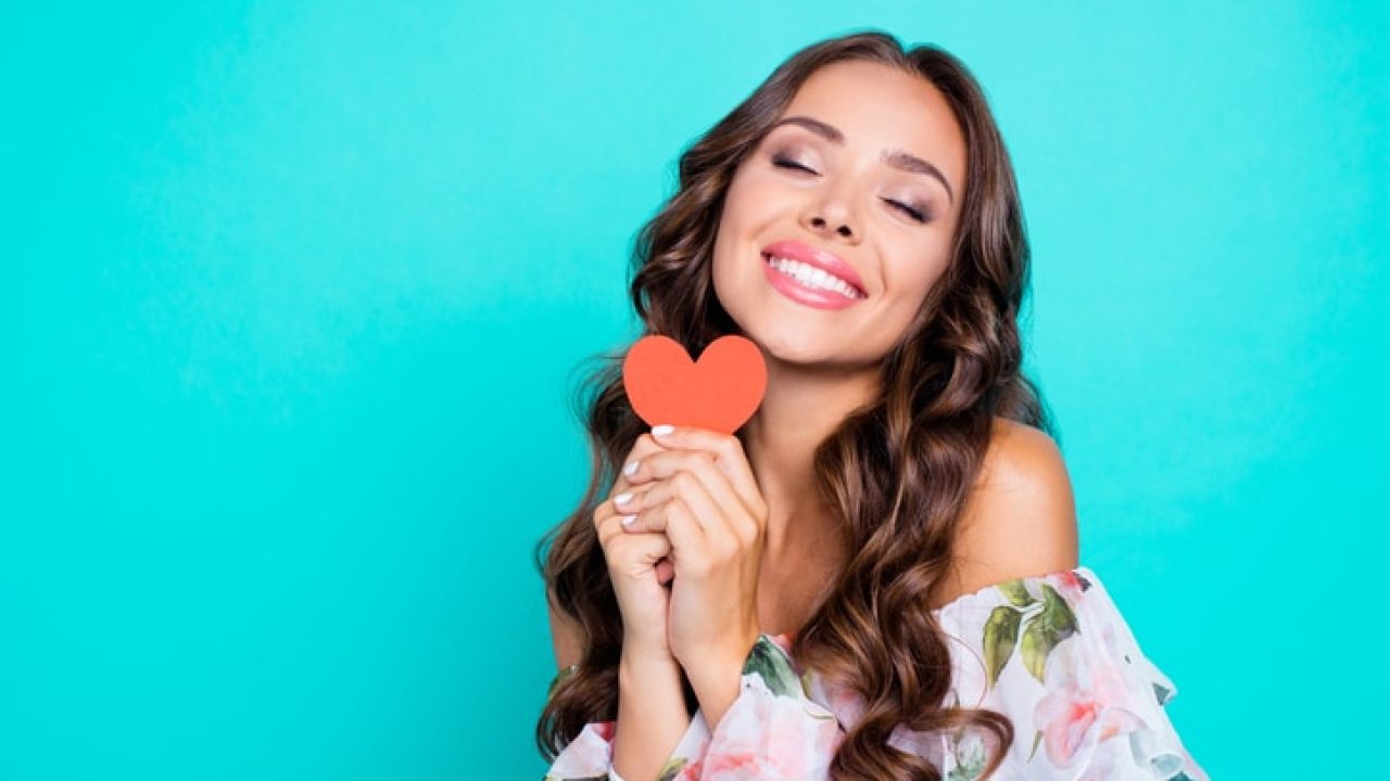 Close up portrait of nice, cute, lovely woman hold one small paper card in hands isolated on shine turquoise background with copy space for text