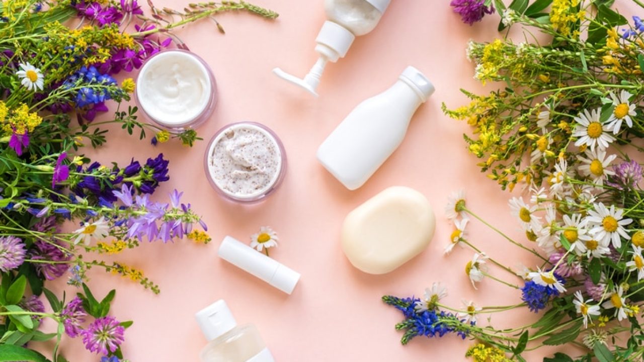 Eco friendly skincare. Natural cosmetics and organic herbs and flowers on pink background, top view, flat lay. Bio research and healthy lifestyle concept.